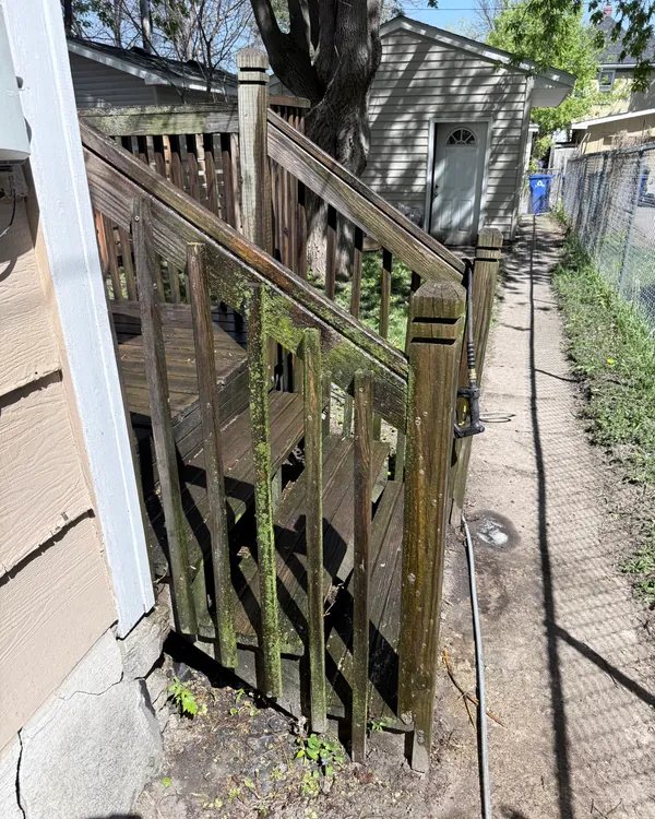 Dark, weathered wood deck stairs and railing before washing