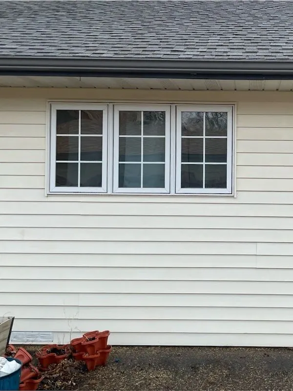 White siding below a row of windows after washing